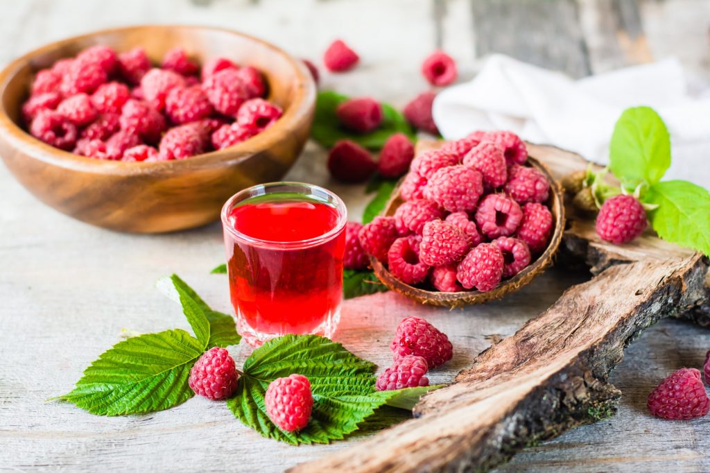 Boiling raspberry drink and berries in a bowl