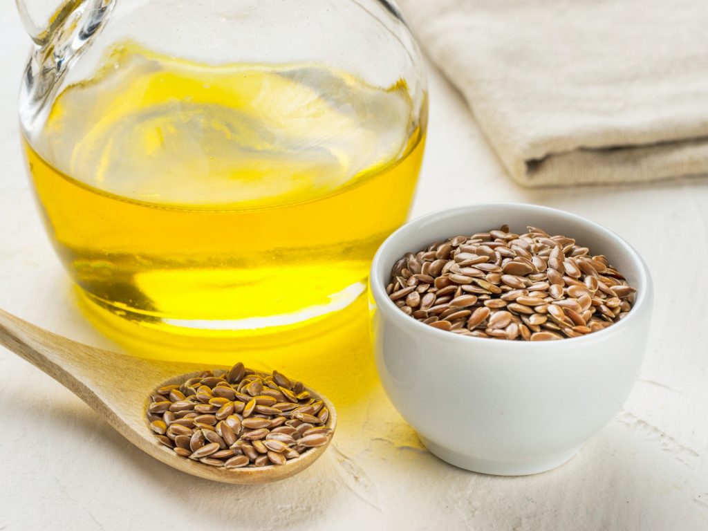 Brown flax seeds in spoon and flaxseed oil